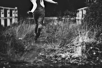 photographersydney/girl skipping at old bridge wearing denim overalls