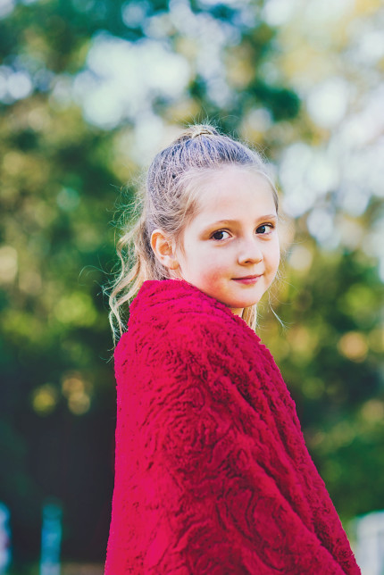 Sydney family photographer/a girl wrapped in a red blanket.