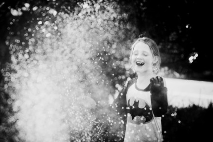 A girl playing in hose in front yard by Sydney Photographer- CIndy Cavanagh