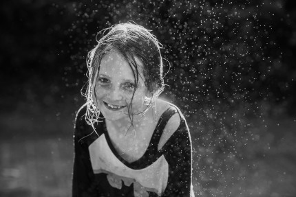 A girl playing in hose in front yard by Sydney Photographer- CIndy Cavanagh
